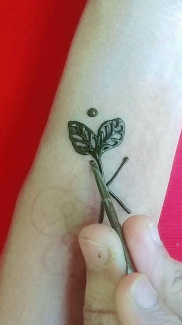 Tiny sprig tattoo on the left side ribcage